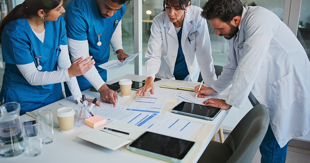 Doctor, people or meeting in hospital with paperwork for patient diagnosis, medical advice or planning. Nurse, healthcare team and conversation for research, documents and collaboration strategy